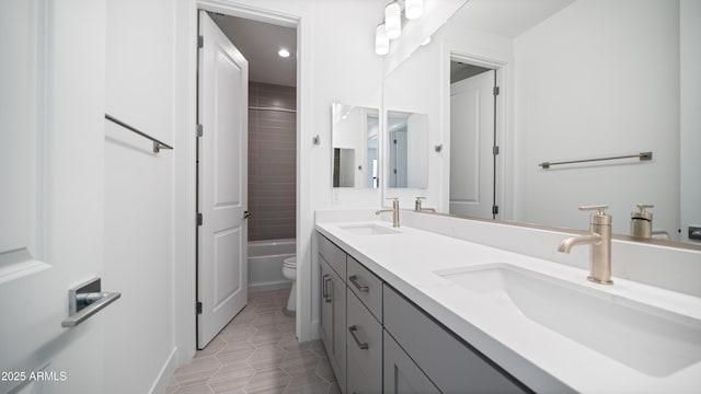 full bath with double vanity, toilet, tile patterned floors, and a sink