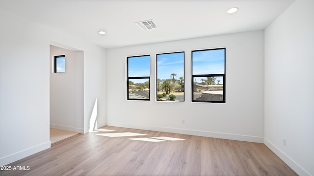 spare room with light wood finished floors, visible vents, recessed lighting, and baseboards