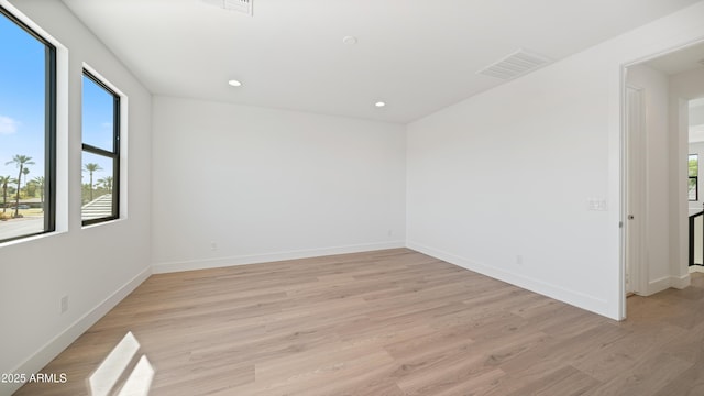 unfurnished room featuring recessed lighting, light wood-type flooring, baseboards, and visible vents