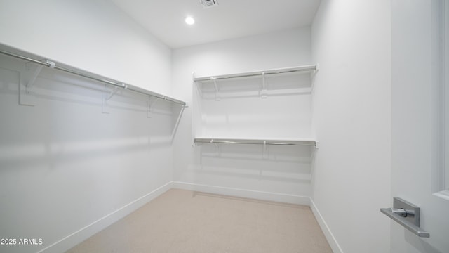 spacious closet with light colored carpet and visible vents