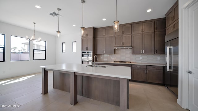 kitchen featuring visible vents, plenty of natural light, stainless steel appliances, a sink, and backsplash