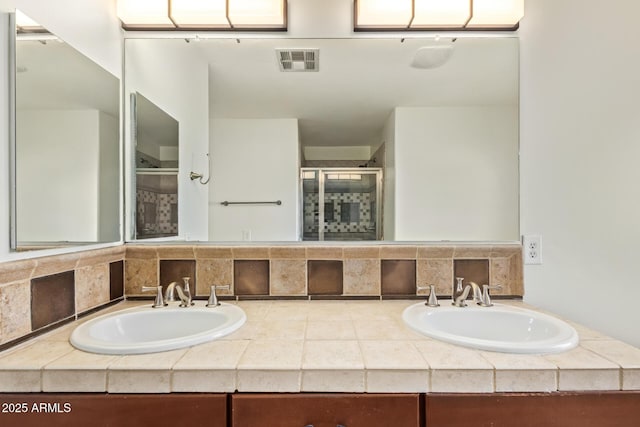 bathroom featuring a shower with door and vanity