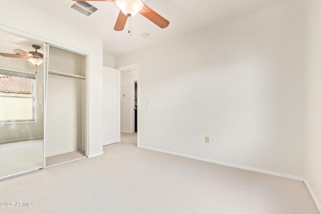 unfurnished bedroom with light carpet, a closet, and ceiling fan