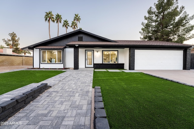 view of front facade featuring a garage and a lawn