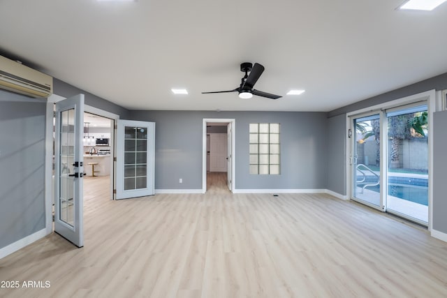 interior space featuring an AC wall unit, light hardwood / wood-style flooring, ceiling fan, and french doors