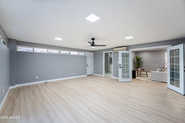 unfurnished room with light wood-type flooring, french doors, and a wall mounted air conditioner