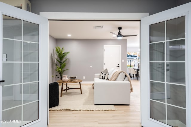 living room featuring light wood-type flooring and ceiling fan