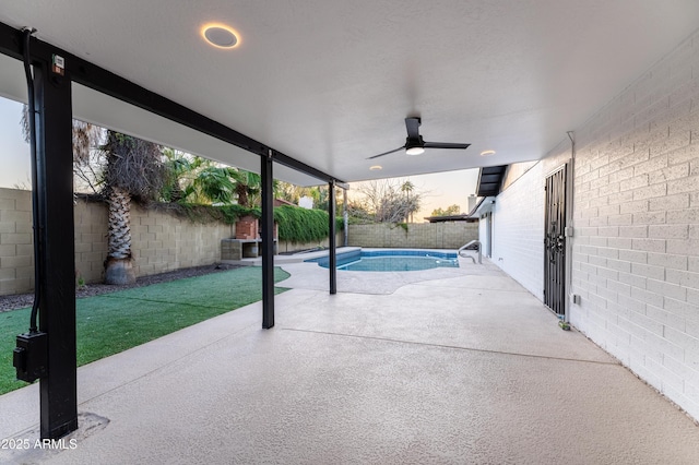 view of swimming pool featuring ceiling fan and a patio