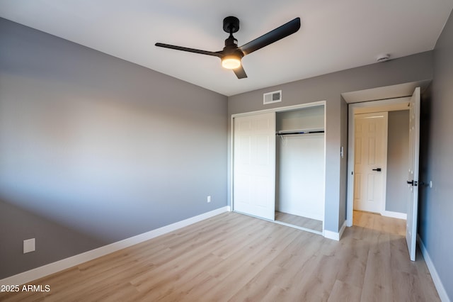 unfurnished bedroom featuring ceiling fan, light hardwood / wood-style floors, and a closet