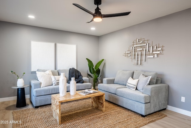 living room featuring hardwood / wood-style floors and ceiling fan