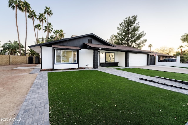 view of front of home with a garage and a lawn