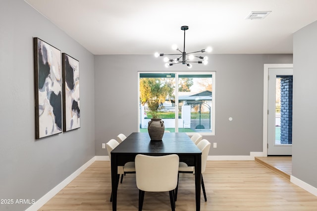 dining room with a notable chandelier and light hardwood / wood-style floors