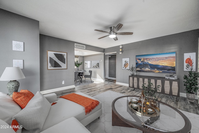 living room with ceiling fan and light hardwood / wood-style flooring