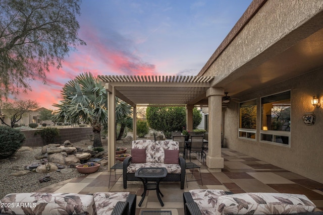 patio terrace at dusk with a pergola, outdoor lounge area, and ceiling fan