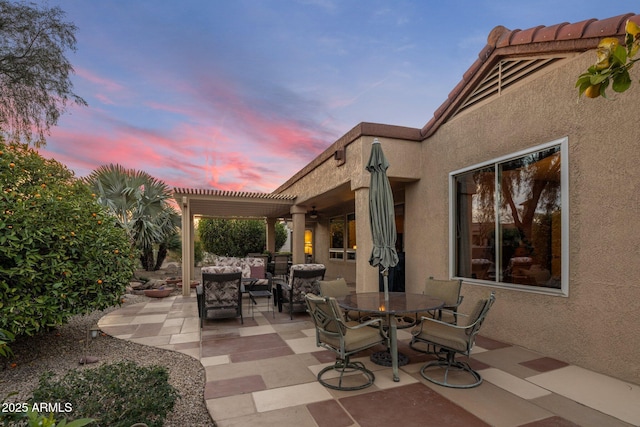 patio terrace at dusk featuring a pergola