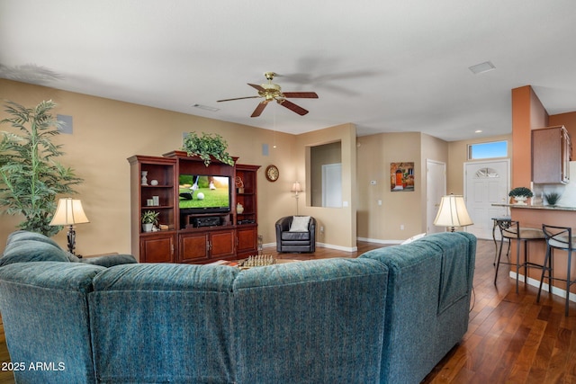 living room featuring dark wood-type flooring and ceiling fan