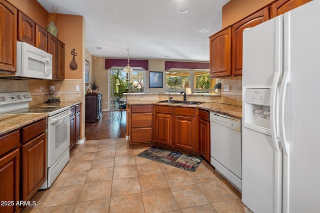 kitchen with sink, white appliances, hanging light fixtures, tasteful backsplash, and light tile patterned flooring