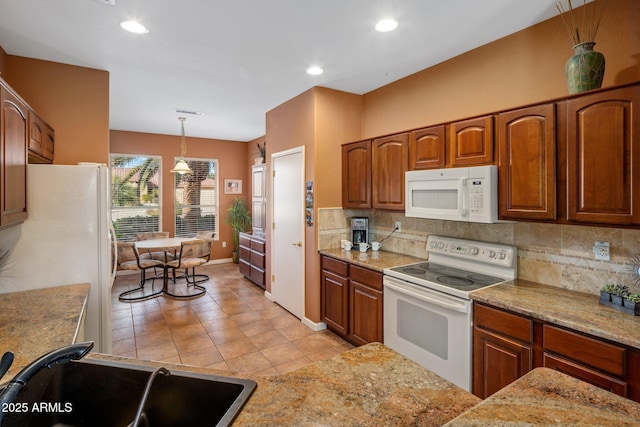 kitchen featuring pendant lighting, sink, white appliances, and decorative backsplash