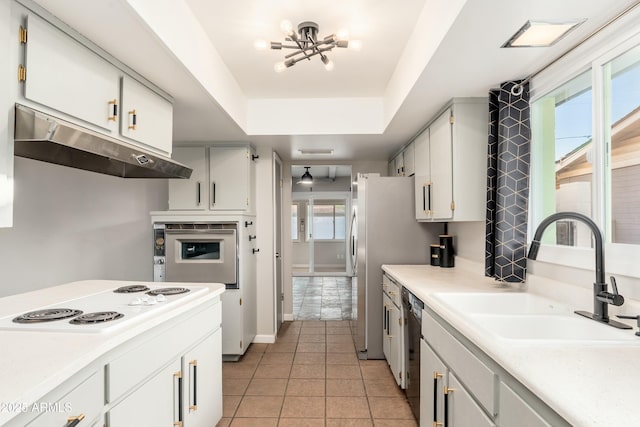 8431 E Rose Ln, Scottsdale, AZ 85250 - kitchen featuring under cabinet range hood, white electric stovetop, a raised ceiling, dishwasher, and a sink
