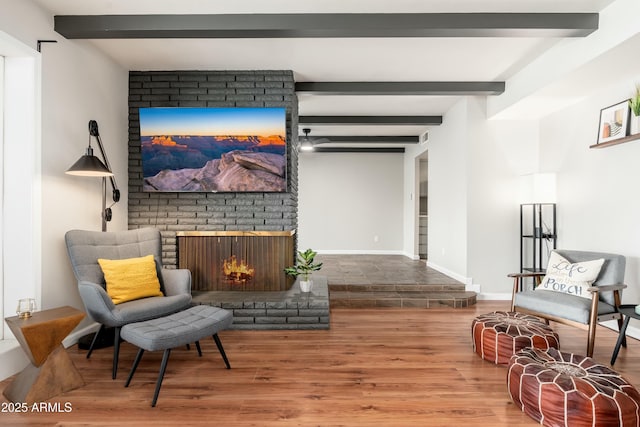 8431 E Rose Ln, Scottsdale, AZ 85250 - sitting room featuring wood finished floors, baseboards, beam ceiling, and a brick fireplace