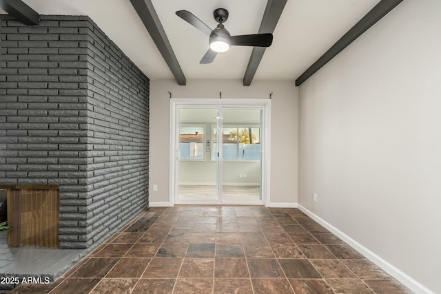 8431 E Rose Ln, Scottsdale, AZ 85250 - unfurnished room with baseboards, a fireplace, a ceiling fan, stone finish floor, and beamed ceiling