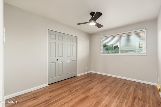 8431 E Rose Ln, Scottsdale, AZ 85250 - unfurnished bedroom with a closet, light wood finished floors, baseboards, and a ceiling fan