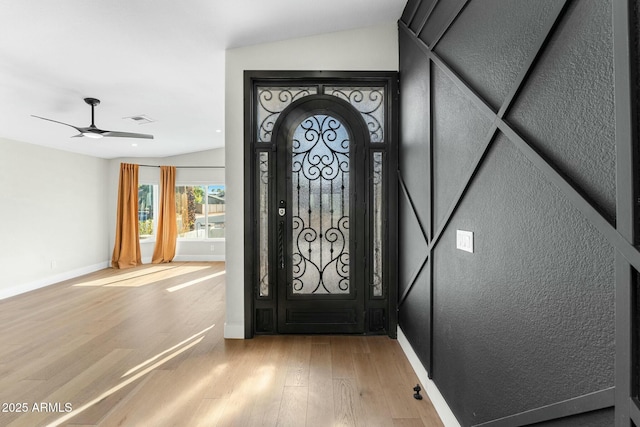 entrance foyer featuring hardwood / wood-style flooring, ceiling fan, and vaulted ceiling