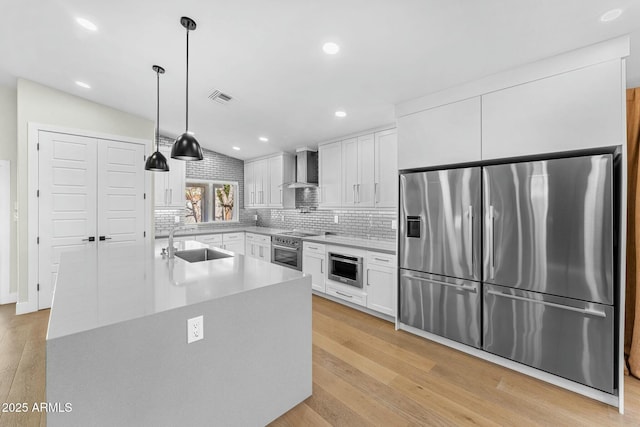 kitchen with appliances with stainless steel finishes, decorative light fixtures, sink, and white cabinets