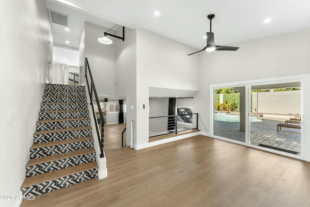 interior space featuring ceiling fan, hardwood / wood-style floors, and a high ceiling