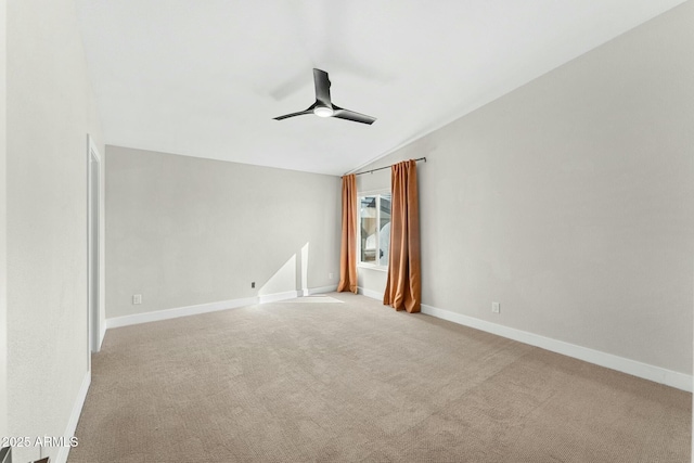 empty room featuring ceiling fan, vaulted ceiling, and light carpet