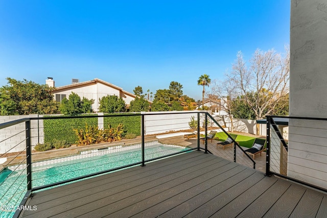 wooden deck with a fenced in pool