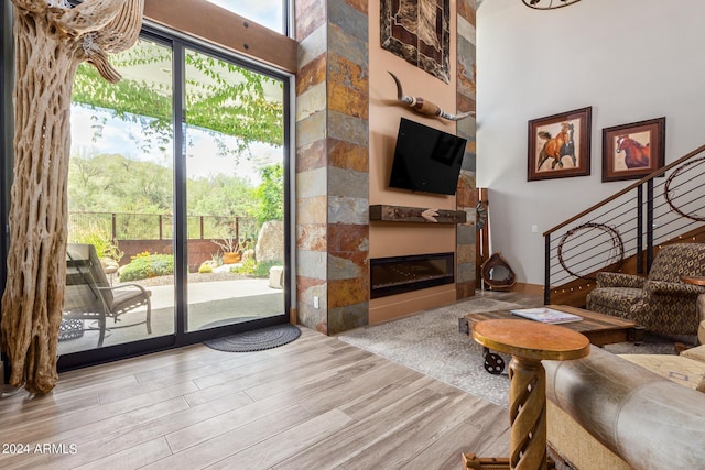 living room featuring a large fireplace, a high ceiling, and light wood-type flooring