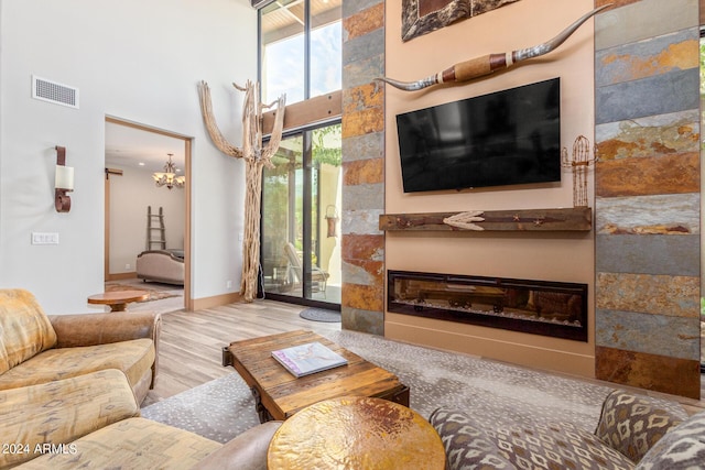 living room with a high ceiling, hardwood / wood-style flooring, and a notable chandelier