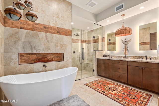 bathroom with tile patterned floors, vanity, tile walls, and independent shower and bath