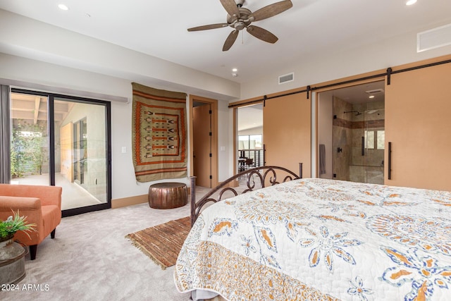 bedroom with ceiling fan, a barn door, ensuite bathroom, carpet floors, and access to outside