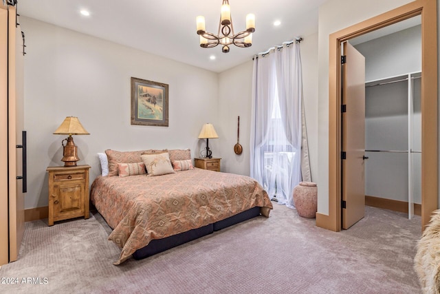 carpeted bedroom featuring a walk in closet, an inviting chandelier, and a closet