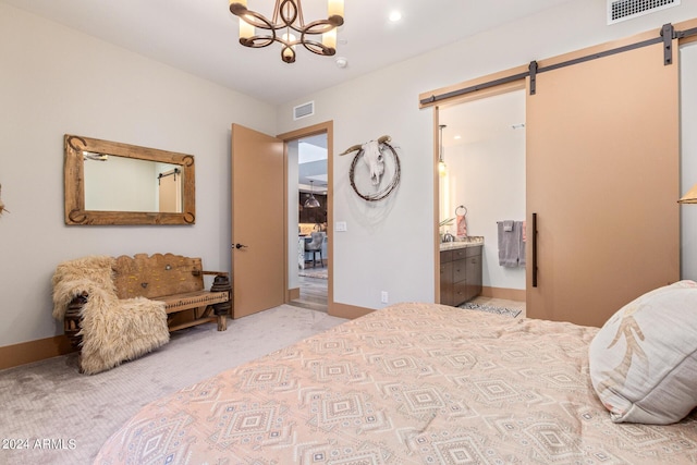 carpeted bedroom with a notable chandelier, a barn door, and connected bathroom