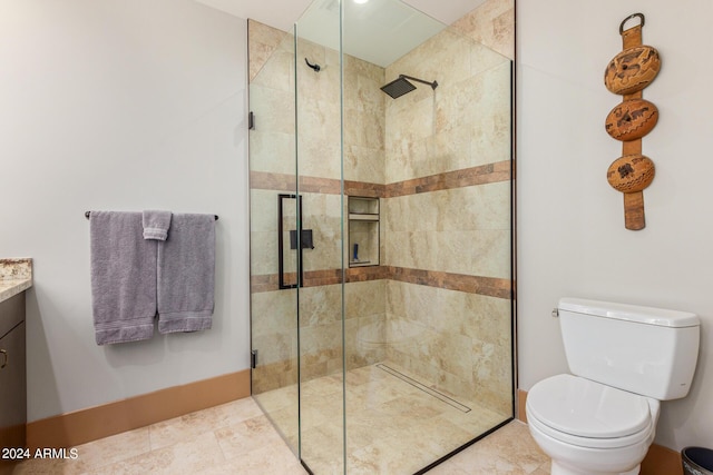 bathroom featuring vanity, an enclosed shower, and toilet