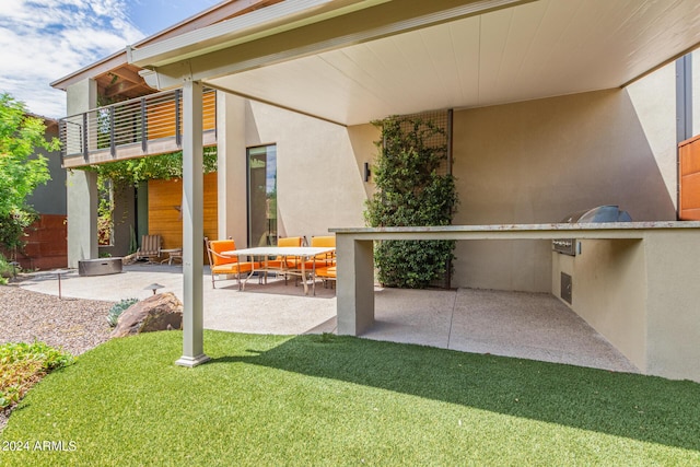 view of patio / terrace featuring a balcony and exterior kitchen