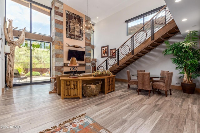 interior space with a chandelier, a towering ceiling, and light hardwood / wood-style flooring