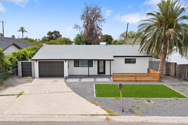 single story home featuring a garage, concrete driveway, and a shingled roof