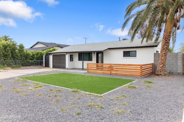 ranch-style home with fence, a garage, driveway, and a shingled roof