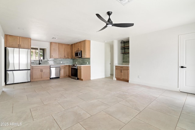 kitchen with appliances with stainless steel finishes, tasteful backsplash, light countertops, and ceiling fan