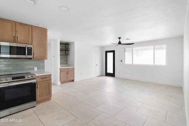 kitchen with appliances with stainless steel finishes, tasteful backsplash, light countertops, baseboards, and a ceiling fan