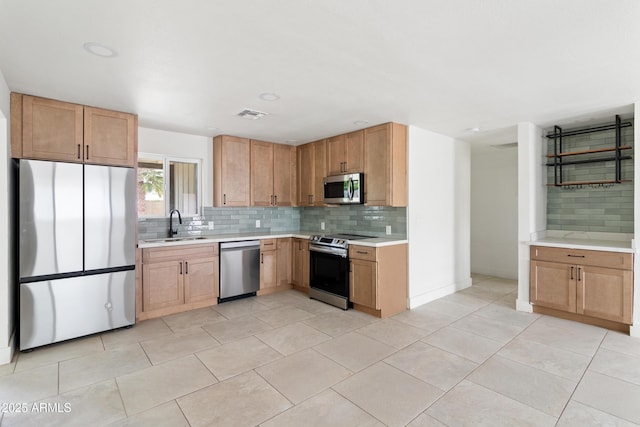 kitchen with stainless steel appliances, a sink, backsplash, light countertops, and light tile patterned floors
