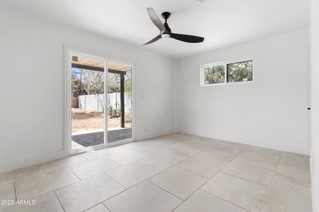 spare room featuring plenty of natural light, ceiling fan, light tile patterned floors, and baseboards