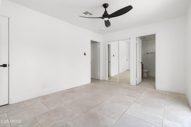 unfurnished bedroom featuring light tile patterned floors, baseboards, ensuite bathroom, and a ceiling fan
