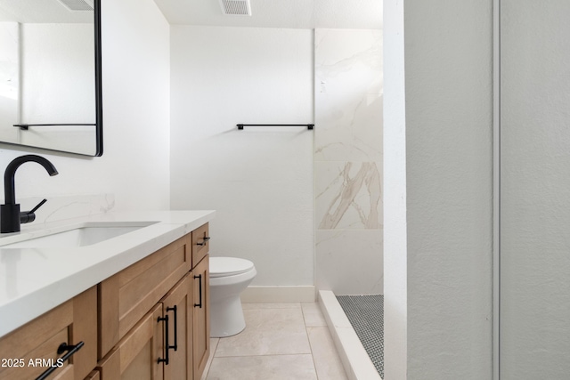 bathroom featuring toilet, tiled shower, and vanity