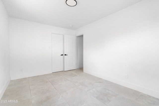 spare room featuring baseboards and light tile patterned floors