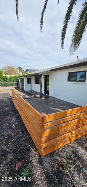 rear view of property featuring a wooden deck